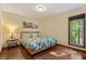 Comfortable bedroom featuring hardwood floors, a large window, and a cozy queen-sized bed at 6160 Virgilina Rd, Roxboro, NC 27574