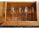 Close-up of a wooden cabinet showcasing glassware at 6160 Virgilina Rd, Roxboro, NC 27574