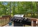 Outdoor deck featuring a grill and wooded scenery, perfect for enjoying outdoor cooking and nature views at 6160 Virgilina Rd, Roxboro, NC 27574