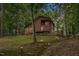 Beautiful wooded cabin style home featuring exterior lighting and a balcony with screened in porch at 6160 Virgilina Rd, Roxboro, NC 27574