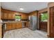 Well-lit kitchen with stainless steel appliances, wooden cabinets, and a door to the outside at 6160 Virgilina Rd, Roxboro, NC 27574