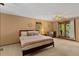 Serene main bedroom with a queen-size bed, neutral tones, and natural light from balcony doors at 6160 Virgilina Rd, Roxboro, NC 27574