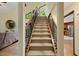 Staircase with carpet and decorative metal banister leads to upstairs, with a view of the living room and kitchen at 6160 Virgilina Rd, Roxboro, NC 27574