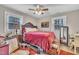 Comfortable bedroom featuring a plush red bedspread, classic wooden furniture, and ample natural light at 715 Shay Dr, Durham, NC 27704
