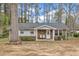 Charming single-story home featuring brick and vinyl siding, a covered porch, and mature trees in the front yard at 715 Shay Dr, Durham, NC 27704