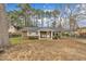 Quaint single-story home with brick and vinyl accents, a cozy porch, and a fenced yard, surrounded by mature trees at 715 Shay Dr, Durham, NC 27704