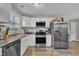 Bright kitchen features stainless steel appliances, white cabinetry, and updated countertops for a modern feel at 715 Shay Dr, Durham, NC 27704
