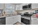 Well-lit kitchen featuring white cabinets, stainless steel appliances, and granite countertops, perfect for cooking and entertaining at 715 Shay Dr, Durham, NC 27704