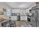 Bright eat-in kitchen with white cabinets, stainless steel appliances, and a view to the backyard at 715 Shay Dr, Durham, NC 27704