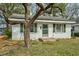 Charming one-story home with white brick, green shutters, and mature trees at 740 Long Ave, Rocky Mount, NC 27801