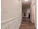 Hallway featuring wood-look floors, wainscoting, light-colored walls and white trim at 78 Florence Dr, Clayton, NC 27527