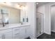 Modern bathroom featuring double sinks, sleek white cabinetry, and a glass-enclosed shower for a spa-like experience at 802 Hillfarm Dr, Wake Forest, NC 27587