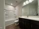 Well-lit bathroom with a single vanity, sleek fixtures, and a shower-tub combo at 802 Hillfarm Dr, Wake Forest, NC 27587