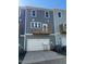 Townhome exterior with two-car garage, complemented by a cozy second-story deck at 802 Hillfarm Dr, Wake Forest, NC 27587