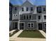 Charming three-story townhome featuring a modern color scheme and well-manicured landscaping at 802 Hillfarm Dr, Wake Forest, NC 27587
