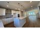 New kitchen features stainless hood, tiled backsplash, and eat-in island with pendant lights above at 802 Hillfarm Dr, Wake Forest, NC 27587