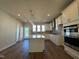Modern kitchen features stainless steel appliances, a tiled backsplash, and a large island with a quartz countertop at 802 Hillfarm Dr, Wake Forest, NC 27587