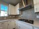 Close-up of the kitchen area, featuring a gas range, stylish backsplash, and white cabinets at 802 Hillfarm Dr, Wake Forest, NC 27587