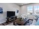 Cozy living room with a plush sofa, a coffee table, and a large window offering natural light at 802 Hillfarm Dr, Wake Forest, NC 27587