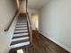 Staircase has wooden railings and treads, and flows into the open-concept main floor living space at 802 Hillfarm Dr, Wake Forest, NC 27587