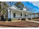 Quaint home showcasing a cozy covered porch, steps leading up to the entrance, and mature trees at 922 Nashville Rd, Rocky Mount, NC 27803