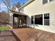 Back of the house with a wooden deck and a screened-in porch overlooking the green backyard at 10004 Liana Ln, Raleigh, NC 27613