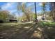 Large backyard with mature trees, outbuildings, and a home visible in the background at 10004 Liana Ln, Raleigh, NC 27613