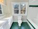 Bathroom with green tiled floors, white tiled walls, and natural light from window at 10004 Liana Ln, Raleigh, NC 27613