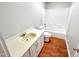Full bathroom with a single sink vanity and a shower-tub with white tiled walls at 10004 Liana Ln, Raleigh, NC 27613