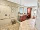 Well-lit bathroom featuring granite countertop sink, frameless glass shower, and tiled floors at 10004 Liana Ln, Raleigh, NC 27613
