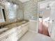 Bathroom with dual sinks, granite countertops, and decorative wallpaper at 10004 Liana Ln, Raleigh, NC 27613