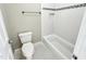 Bright bathroom featuring a white toilet, white tiled shower-tub, and a hexagon tile floor at 10004 Liana Ln, Raleigh, NC 27613