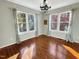 Bedroom with hardwood floors, natural light, two large windows, and modern light fixture at 10004 Liana Ln, Raleigh, NC 27613
