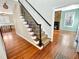 Foyer area featuring hardwood floors, staircase with decorative iron railing, and a glimpse of the living room at 10004 Liana Ln, Raleigh, NC 27613