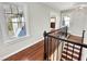 Upstairs hallway features hardwood floors, natural light, chandelier, and wrought iron railing at 10004 Liana Ln, Raleigh, NC 27613