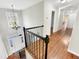 Hallway featuring hardwood floors, wrought iron railing, chandelier, and natural light at 10004 Liana Ln, Raleigh, NC 27613