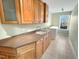 Well-lit laundry room with wood cabinets, countertop, sink, and a front-load washing machine at 10004 Liana Ln, Raleigh, NC 27613