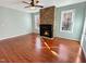 Cozy living room with hardwood floors, stone fireplace, and natural light from windows at 10004 Liana Ln, Raleigh, NC 27613