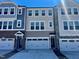 New townhomes featuring varying colors, multi-car garages, and craftsman-style front doors at 10016 Secluded Garden Drive Rd # 186, Apex, NC 27523