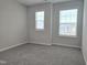 Simple bedroom with gray carpet and two windows at 10018 Secluded Garden Drive Rd # 187, Apex, NC 27523