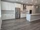Spacious kitchen featuring white cabinets, stainless steel appliances, a large island, and modern pendant lighting at 10018 Secluded Garden Drive Rd # 187, Apex, NC 27523