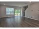 Bright living room with large windows, access to a deck, and staircase at 10018 Secluded Garden Drive Rd # 187, Apex, NC 27523