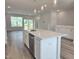 Bright kitchen island with stainless steel appliances, white cabinets, and modern countertops at 10020 Secluded Garden Drive Rd # 188, Apex, NC 27523