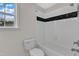 Well-lit bathroom with a bathtub and shower combo and classic black and white tile accents at 102 Switchback St, Knightdale, NC 27545