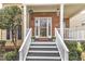 Inviting front porch featuring brick accents, a white railing, and a welcoming entrance at 102 Switchback St, Knightdale, NC 27545