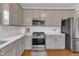 Updated kitchen featuring stainless steel appliances, light gray cabinetry, and modern lighting at 102 Switchback St, Knightdale, NC 27545