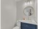 Stylish powder room with a marble countertop, round mirror, and modern fixtures at 102 Switchback St, Knightdale, NC 27545