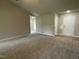 Open-concept living room with neutral carpet, adjacent to foyer, and access to other rooms at 103 Oakfield Trace Dr, Four Oaks, NC 27524