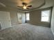 Spacious main bedroom with tray ceiling, plush carpeting, and ensuite bath access at 103 Oakfield Trace Dr, Four Oaks, NC 27524