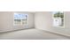 Bright bedroom featuring neutral walls, gray carpet and two sunny windows at 104 Pisgah St, Sanford, NC 27330